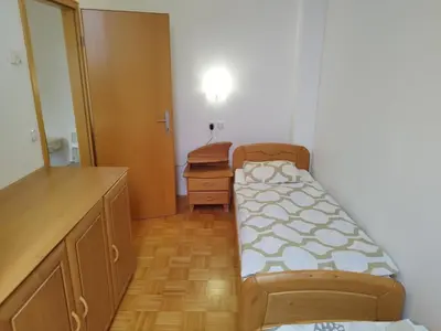 a small room with a bed and a dresser at Apartma Valerija in Zreče