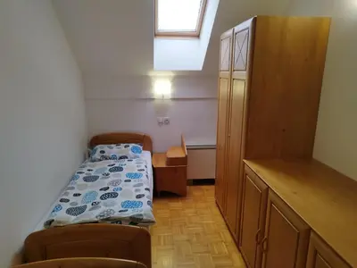 a small room with a bed and a cabinet at Apartma Valerija in Zreče