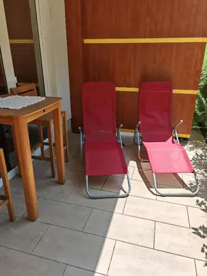 two pink chairs and a table on a patio at Sunflower Apartment Moravske Toplice in Moravske Toplice