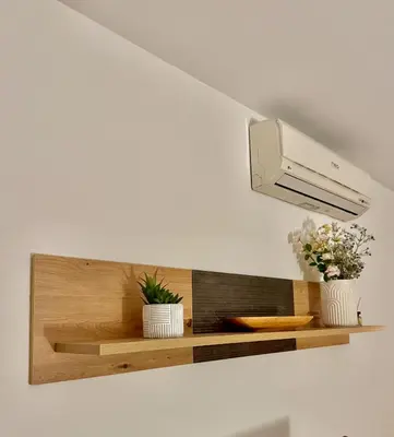 a light on a wall with two plants on a shelf at Sunflower Apartment Moravske Toplice in Moravske Toplice