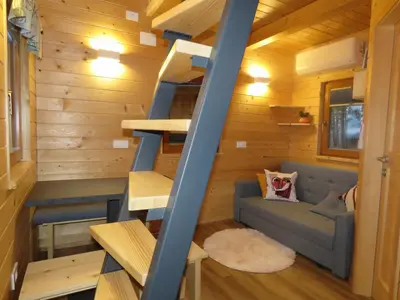 a tiny house with a staircase and a couch at Turistična kmetija Okršlan in Škofja Loka
