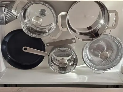 a group of four pots and pans on a shelf at Apartment Barje II, bright&sunny, private parking in Ljubljana