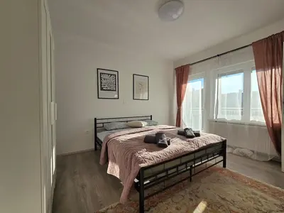 a bedroom with a bed and a large window at Apartment Barje II, bright&sunny, private parking in Ljubljana
