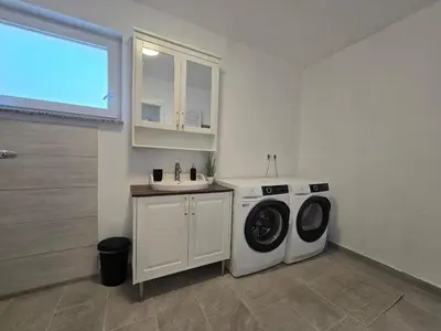 a laundry room with a washing machine and a sink at Apartment Barje II, bright&sunny, private parking in Ljubljana