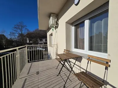 a wooden bench sitting on the balcony of a house at Apartment Barje II, bright&sunny, private parking in Ljubljana