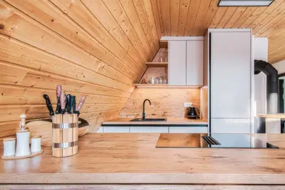 a kitchen with wooden walls and a wooden counter top at Pohorska Gozdna Vila in Pohorje
