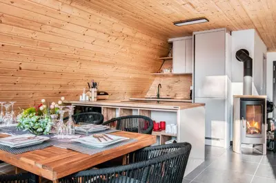 a kitchen and dining room with a table and chairs at Pohorska Gozdna Vila in Pohorje