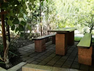 two benches sitting on a patio in a park at Blumauer Apartments in Ljubljana