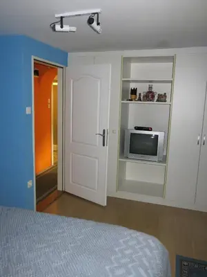 a bedroom with a bed and a door and a tv at Blumauer Apartments in Ljubljana