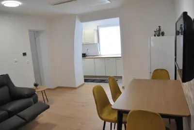 a living room with a table and chairs and a kitchen at Apartma Rače in Rače