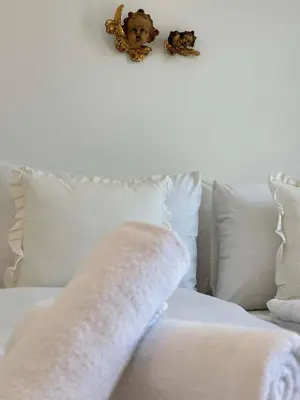 a white couch with pillows and a blanket on it at Angel Wings premium apartment in Ljubljana