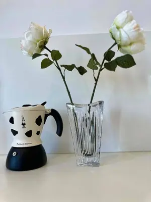 a vase and a vase with white roses in it at Angel Wings premium apartment in Ljubljana
