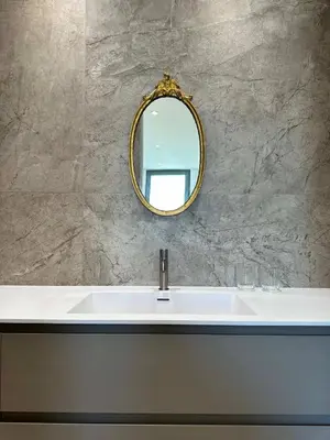 a bathroom sink with a gold mirror on a wall at Angel Wings premium apartment in Ljubljana