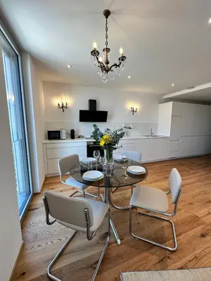 a dining room with a glass table and white chairs at Angel Wings premium apartment in Ljubljana