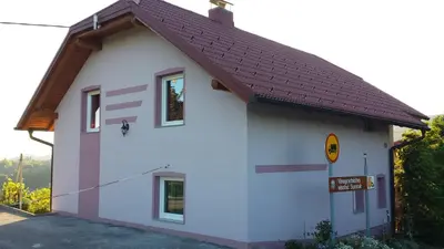 a small white building with a brown roof at Apartment House Sumrak in Bizeljsko