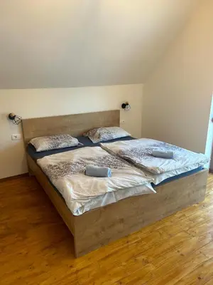 a large bed in a room with a wooden floor at Ana&Borl House in Gradišča