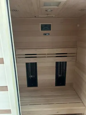 a walk in shower in a room with wooden walls at Ana&Borl House in Gradišča