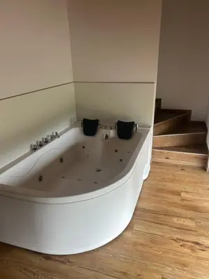 a white bath tub in a room with wooden floors at Ana&Borl House in Gradišča
