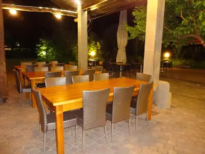 a row of wooden tables and chairs on a patio at Fedrig Private Rooms & Apartment in Kobarid