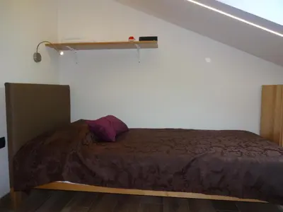 a bedroom with a bed in a room with a staircase at Fedrig Private Rooms & Apartment in Kobarid