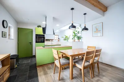 a kitchen and dining room with a wooden table and chairs at Vineyard cottage Kraljevi kotiček in Trebnje