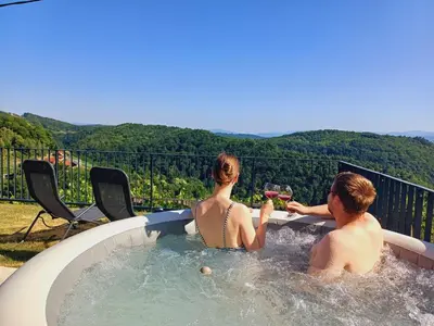 a man and a woman sitting in a hot tub at Vineyard cottage Kraljevi kotiček in Trebnje
