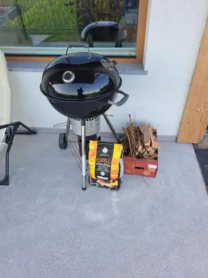 a barbecue grill sitting on a stand next to a house at Vineyard cottage Kraljevi kotiček in Trebnje