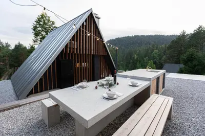 a building with a table and benches on a patio at Pine Hill RUBY with free jacuzzi in Rakitna