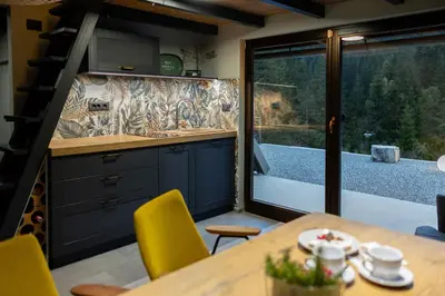 a kitchen with a table and yellow chairs at Pine Hill RUBY with free jacuzzi in Rakitna