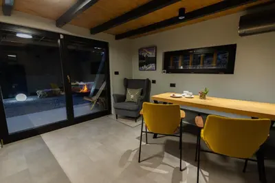 a living room with a table and chairs and a couch at Pine Hill RUBY with free jacuzzi in Rakitna