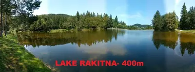 a large lake with trees on the side of it at Pine Hill RUBY with free jacuzzi in Rakitna