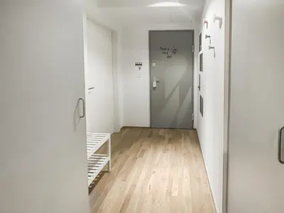 a hallway with white walls and wooden floors and a door at Apartment number 7 in Ljubljana