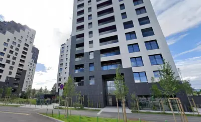 a tall white building with trees in front of it at Apartment number 7 in Ljubljana