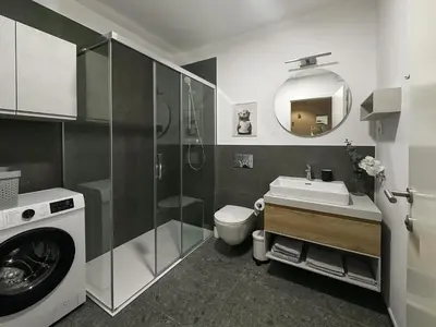 a bathroom with a washing machine and a sink at Apartment number 7 in Ljubljana