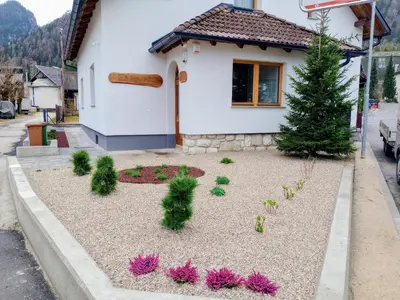 a garden in front of a house with pink flowers at Vila Natalia in Kranjska Gora