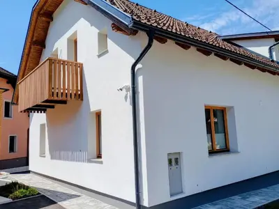 a white house with a balcony on the side at Vila Natalia in Kranjska Gora