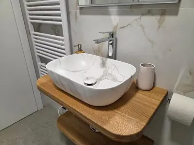 a white sink sitting on a wooden table in a bathroom at Vila Natalia in Kranjska Gora
