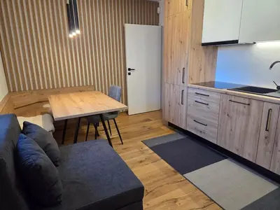 a living room with a couch and a table and a kitchen at Vila Natalia in Kranjska Gora