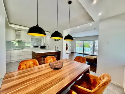 a kitchen and dining room with a wooden table and chairs at Vila SofiOmi in Bled