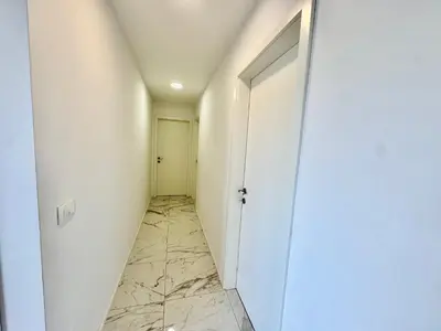 a hallway with a white door and a marble floor at Vila SofiOmi in Bled