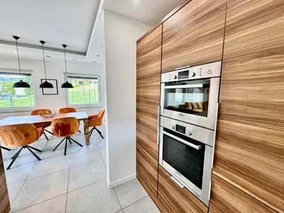 a kitchen with a stove and a dining table at Vila SofiOmi in Bled