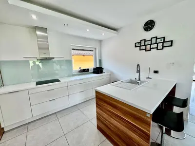 a kitchen with white cabinets and a sink and a window at Vila SofiOmi in Bled