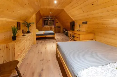 a bedroom with a bed in a wooden cabin at Chalet Vrsnik Hideaway in Soča