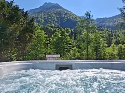 a tub filled with water with mountains in the background at Chalet Vrsnik Hideaway in Soča