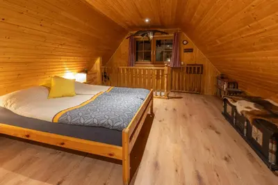 a bedroom with a bed in a wooden cabin at Chalet Vrsnik Hideaway in Soča
