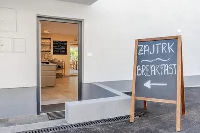 a sign in front of a building with a restaurant at Pension Hosnar, apartma Gusto in Bovec