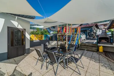 a patio with a table and chairs and a fireplace at Pension Hosnar, apartma Gusto in Bovec