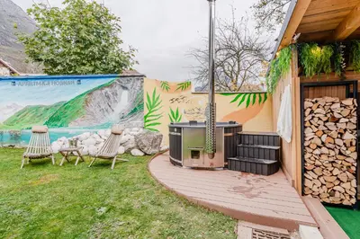 a backyard with a deck with a grill and chairs at Pension Hosnar, apartma Gusto in Bovec