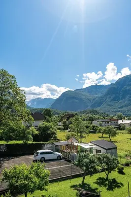 a car parked in a parking lot with mountains in the background at Pension Hosnar, apartma Gusto in Bovec