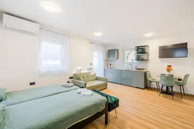 a living room with a bed and a kitchen at Pension Hosnar, apartma Gusto in Bovec